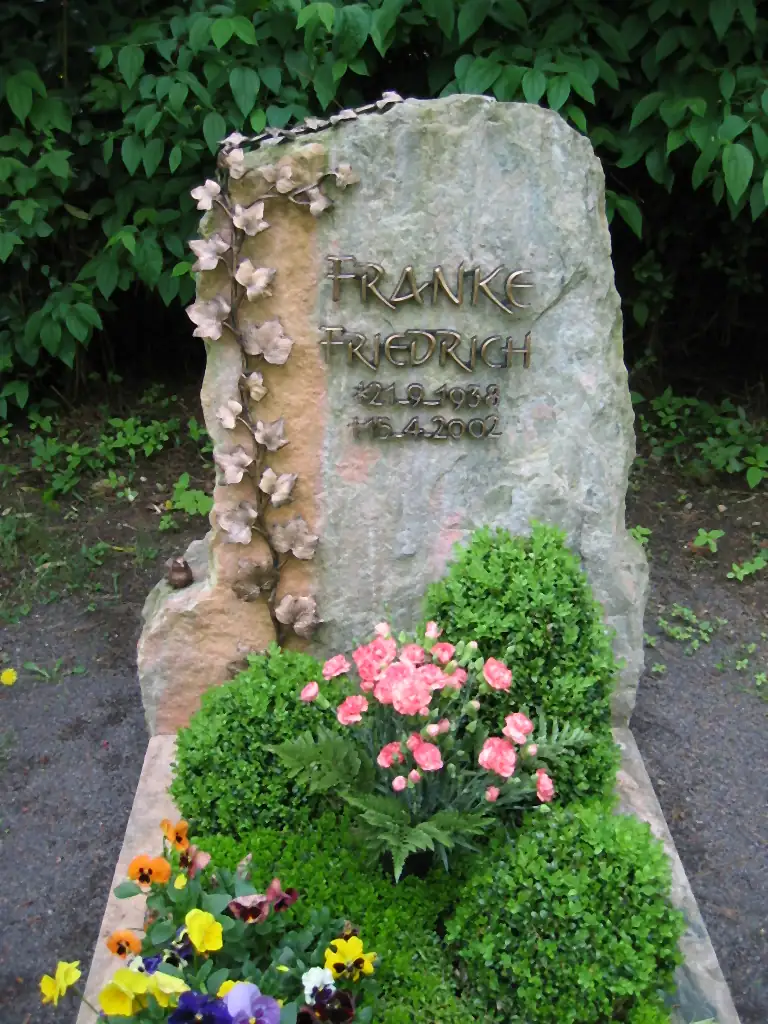 Findling als Grabmal mit bronzener Efeuranke und gemeißelter Schrift