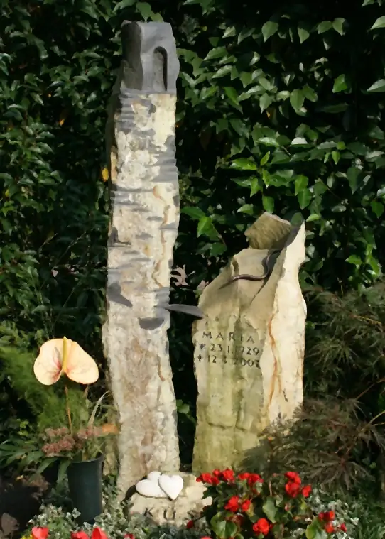 Zweiteiliges Grabmal aus bruchrauem Naturstein mit Bronzeeinlage